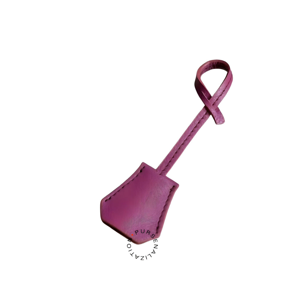 An image of a clochette leather charm for handbags accessories in the variety Brouillard, a shade of rose taupe.