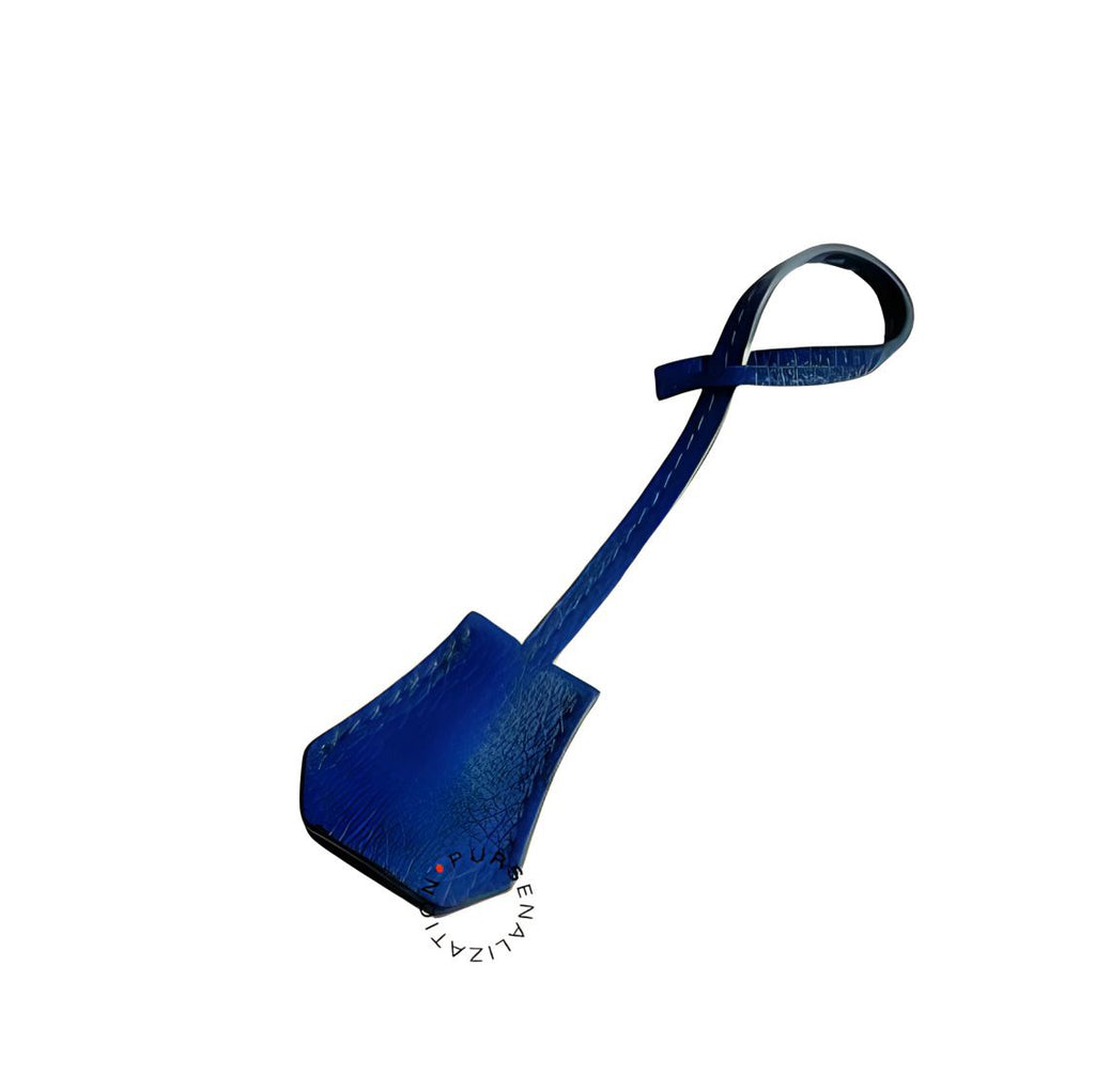 An image of a clochette leather charm for handbags accessories in the variant Etoile, a shade of royal blue.